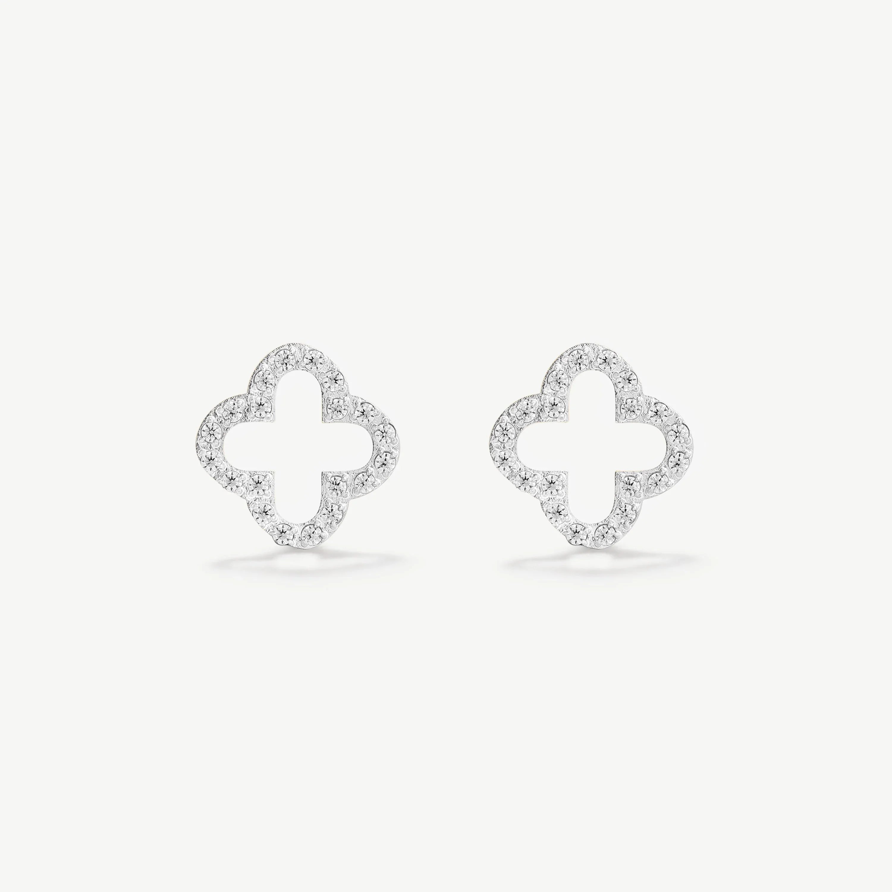 Pair of diamond pavé clover shaped stud earrings on white background