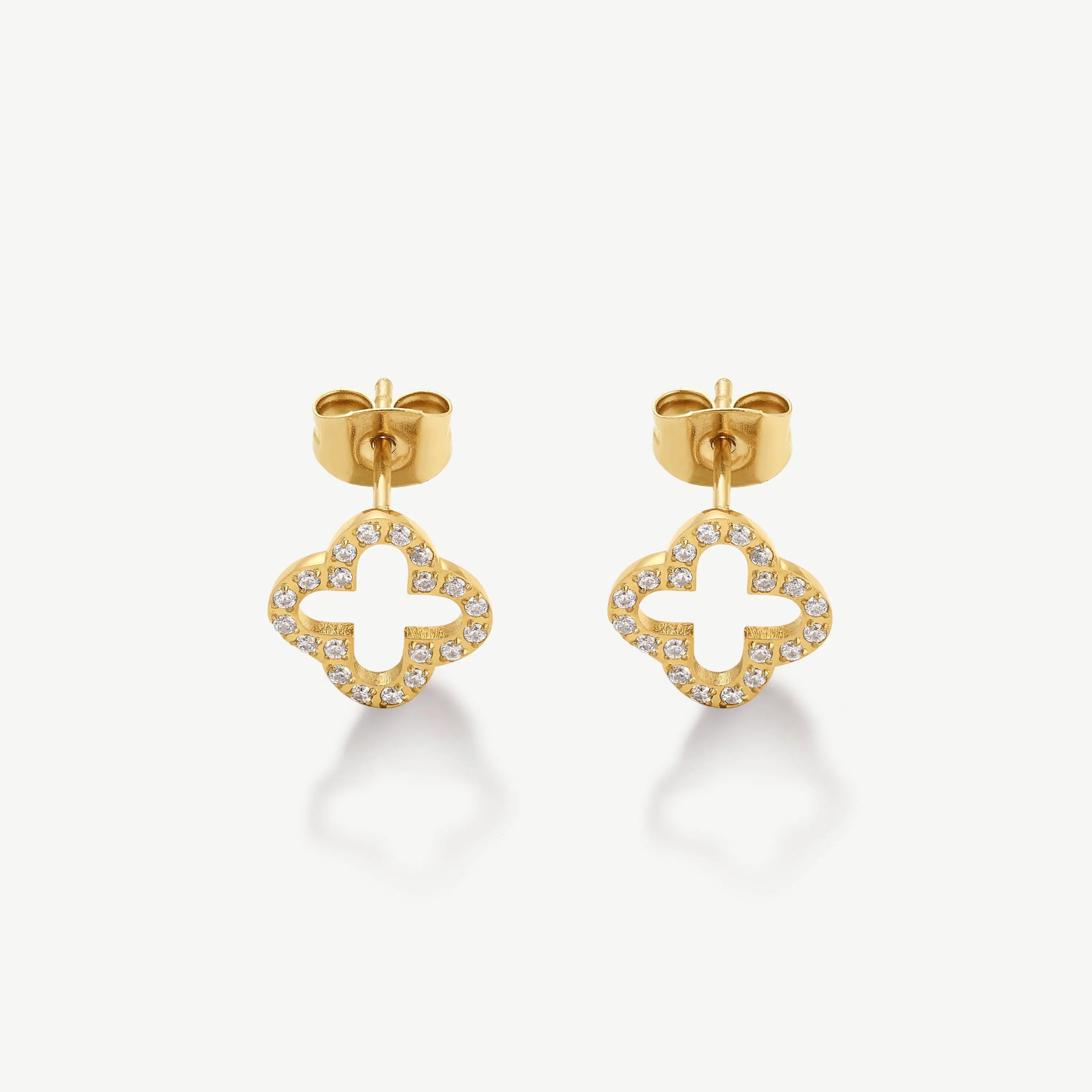 Gold stud earrings in open clover shape with embedded small diamonds on white background